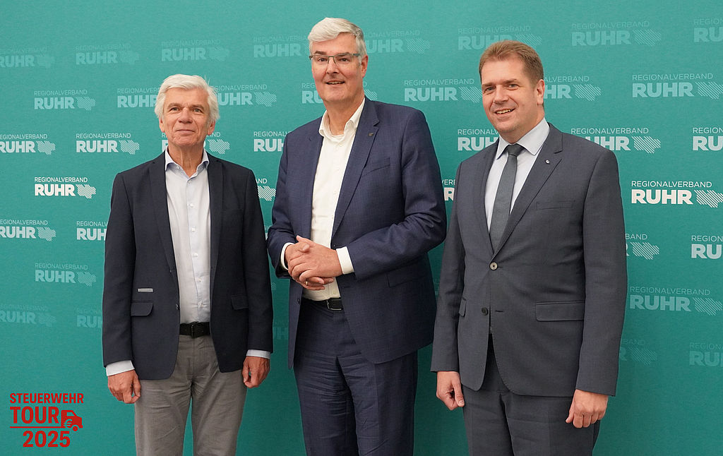(v.l.:) BdSt-Projektleiter Jens Ammann, RVR-Beigeordneter Wirtschaft Markus Schlüter sowie Rik Steinheuer, Vorsitzender des BdSt NRW. Gruppenfoto von drei Männern im Anzug vor einer Pressewand des Regionalverbands Ruhr mit türkisfarbenem Hintergrund