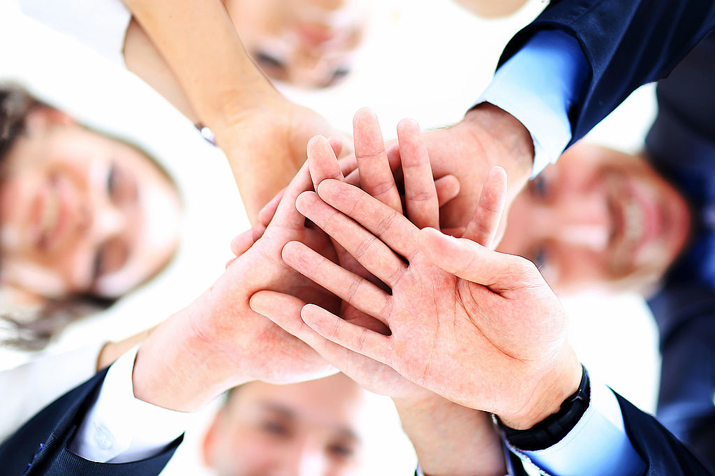 Small group of business people joining hands