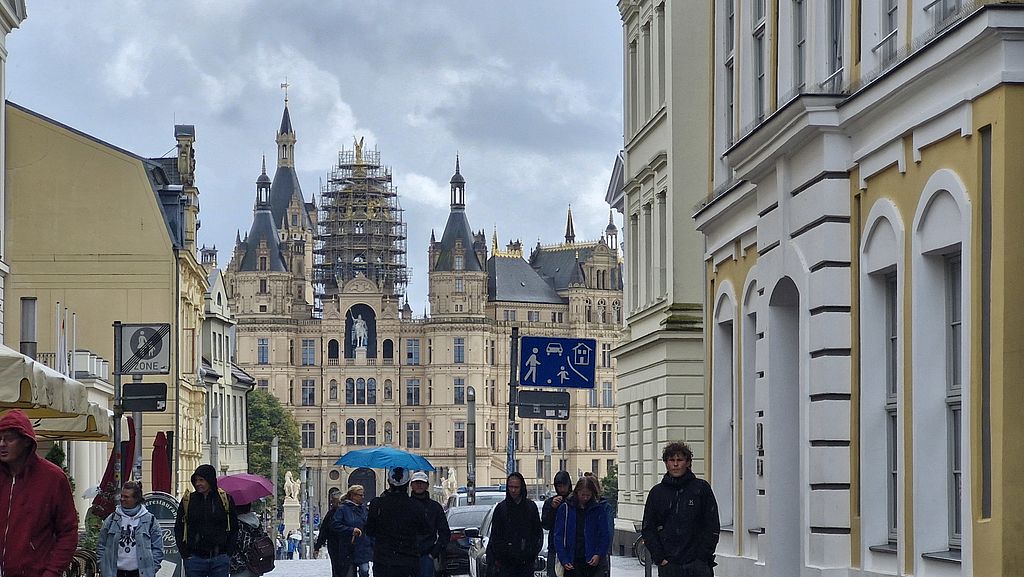 Schweriner Schloss mit Gerüst an der Goldenen Kuppel und Touristen davor
